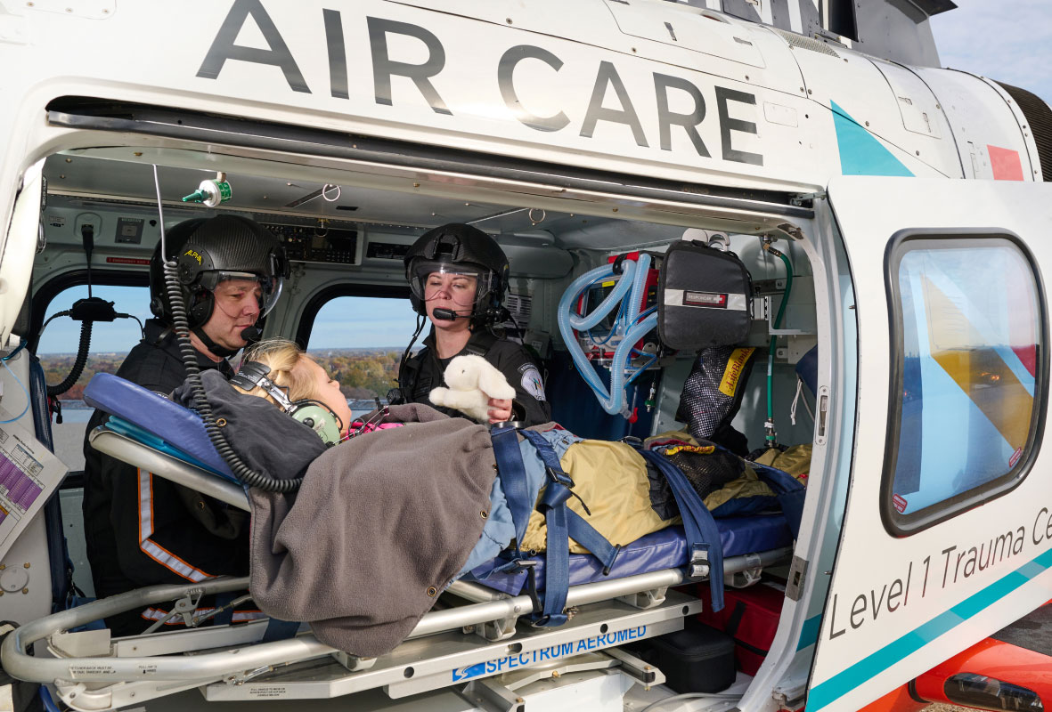Air care team members tending to a young patient in a helicopter